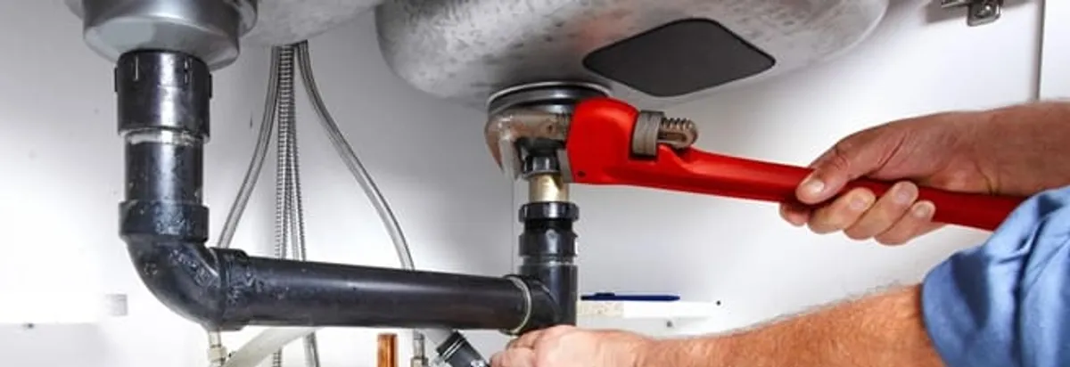 Garbage disposal repair technician tightening the sink drain and disposal connection in Cedar Rapids, IA