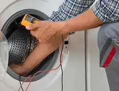 Washing machine repair technician testing a front-load washer with diagnostic tools in Cedar Rapids, IA