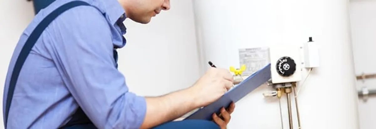 Water heater repair technician inspecting the unit and recording service notes in Cedar Rapids, IA